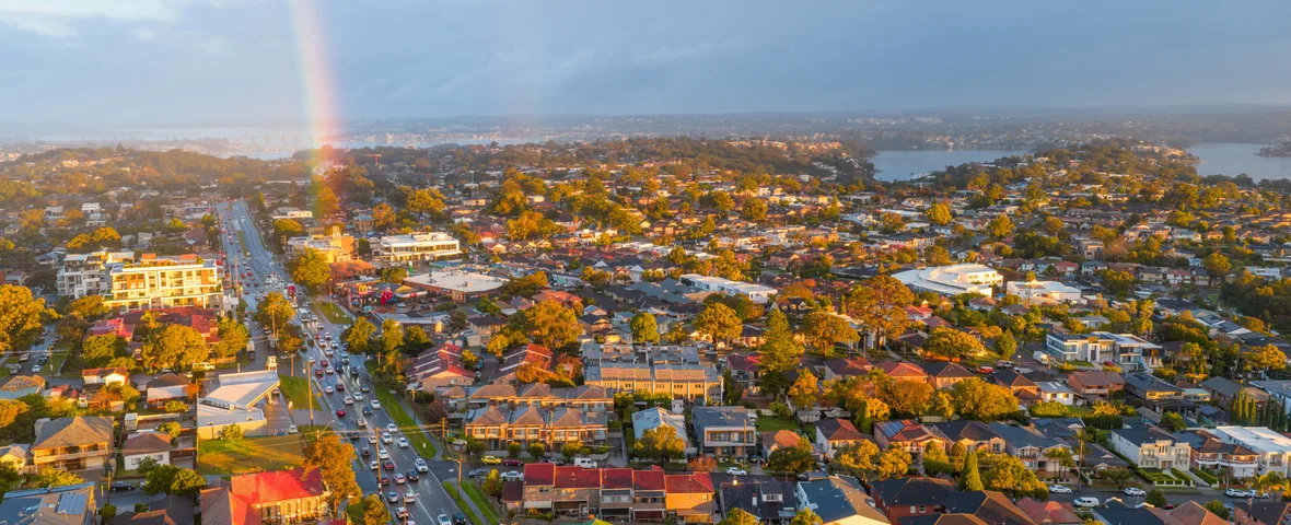 Aerial composite of Australian suburbs showing Sydney terrace housing and Perth single-storey corridors in May 2026